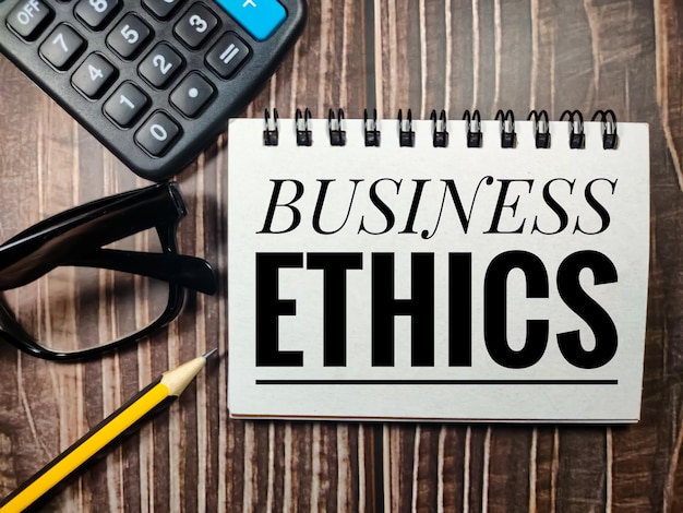 Business conceptText BUSINESS ETHICS avec calculatorglasses et crayon sur un fond de bois marron