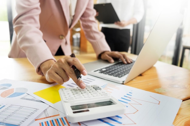 Section médiane d'une femme d'affaires utilisant une calculatrice