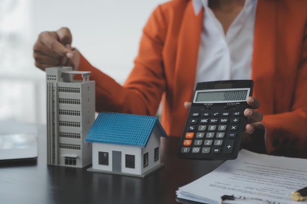 Mains de femme tenant le modèle de maison petite maison de jouet blanche miniature Assurance de propriété hypothécaire rêve de déménagement et concept immobilier