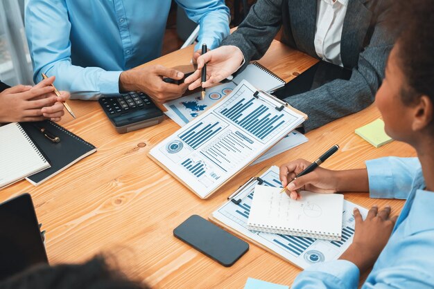Une équipe d'analystes multiraciaux utilise les données du tableau de bord BI pour analyser le rapport financier sur la table de réunion Un groupe de gens d'affaires divers utilise l'analyse des données par FIntech pour prendre des décisions de marketing commercial Concord