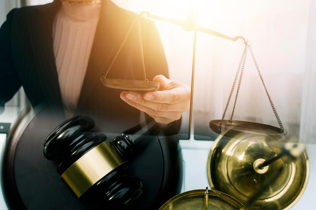 Les entreprises et les avocats discutent des documents contractuels avec une balance en laiton sur le bureau du bureau Les services juridiques Les conseils sur la justice et le concept du droit