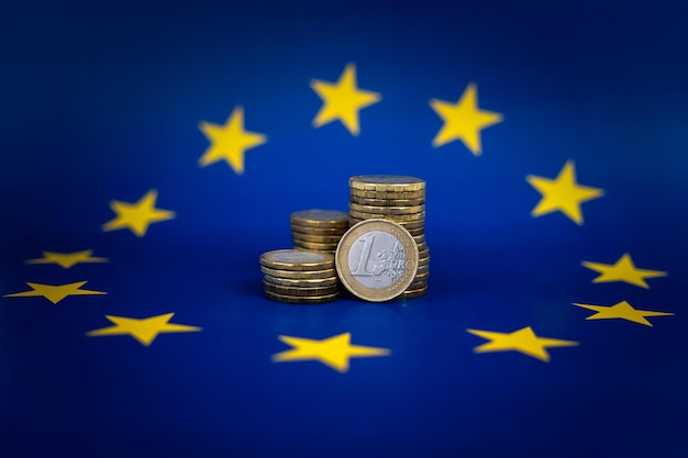 Les pièces en euros sur le fond du drapeau européen La notion de financement européen Les affaires et le travail en Europe