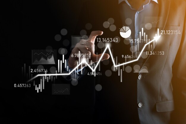 Homme d'affaires à la main tenir le graphique de financement des entreprises bancaires et investir dans le point d'investissement boursier, la croissance économique et le concept d'investisseur.analyse graphique boursier virtuel, analyser par technologie d'utilisation