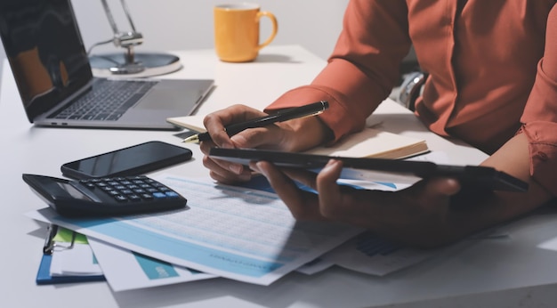 Travailler à domicile femme d'affaires en gros plan utilisant un ordinateur portable et analysant des rapports financiers